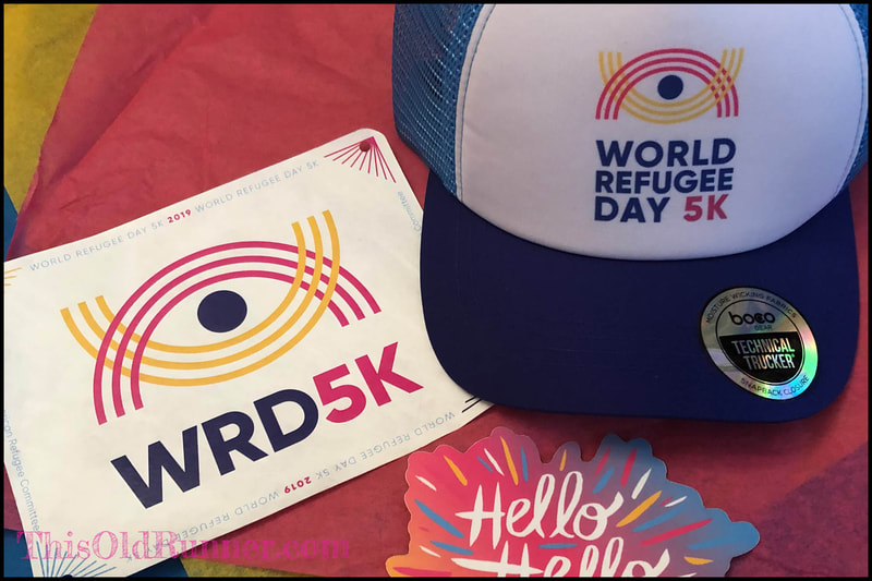 Race bib and trucker hat for World Refugee Day 5K virtual race.