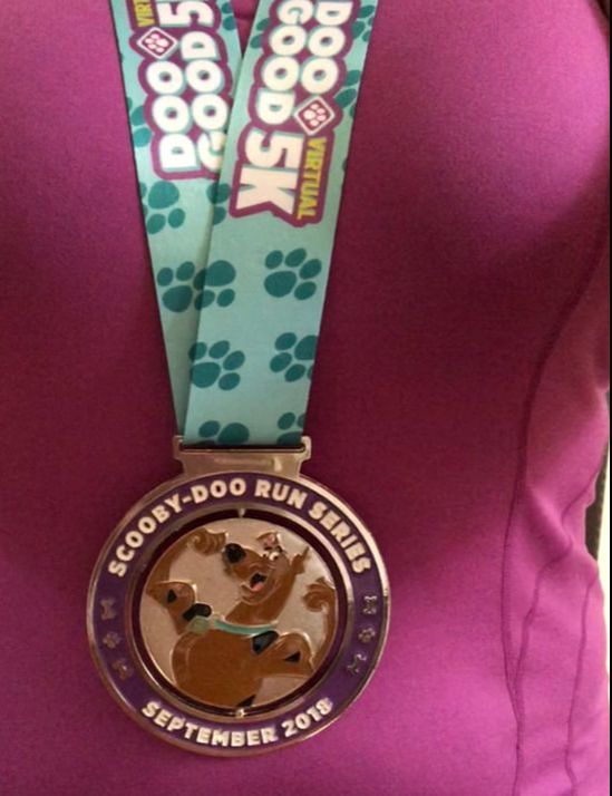 Wearing a Scooby DooGood 5K finisher medal.