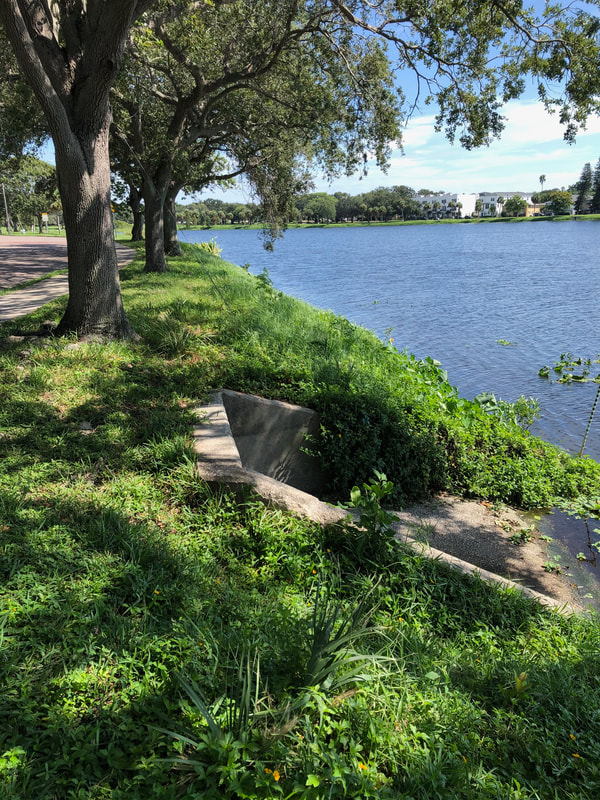 View of a lake with sidewalks around it.
