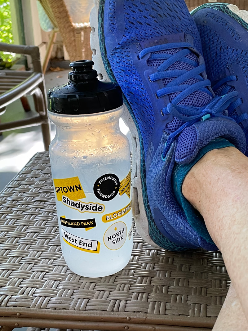 Pittsburgh water bottle on table next to runner's feet.